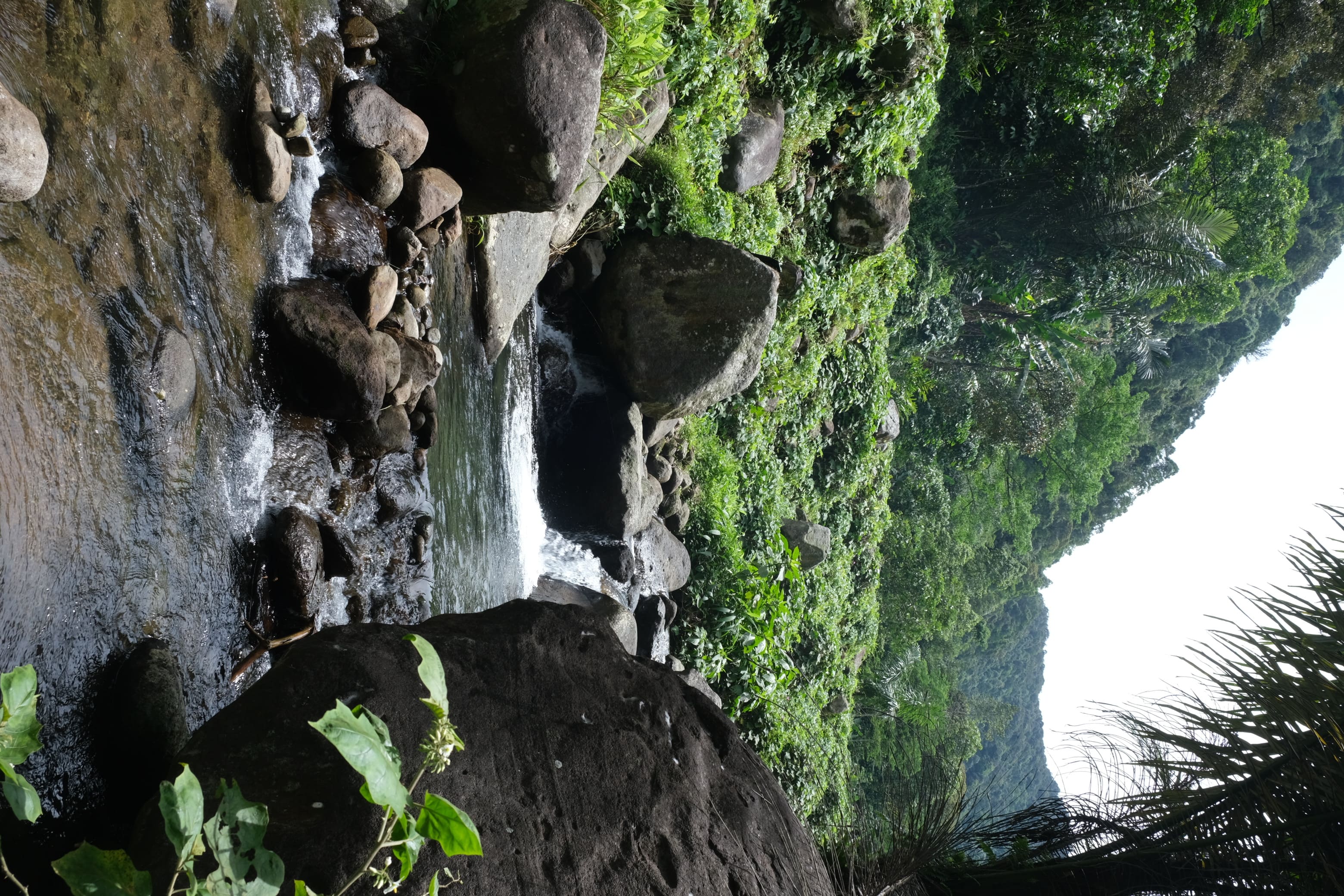 Sungai Alam dengan Latar Pegunungan Hijau